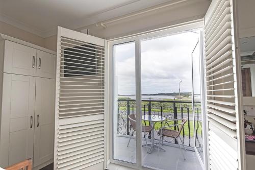 a room with a balcony with a table and chairs at Sea Breeze Lodge B&B Galway in Galway