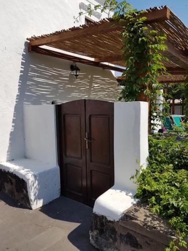 a small house with a brown door and some bushes at Stromboli Vacanze in Stromboli