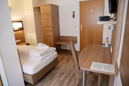 a small room with a bed and a table at La Stella in Süßen