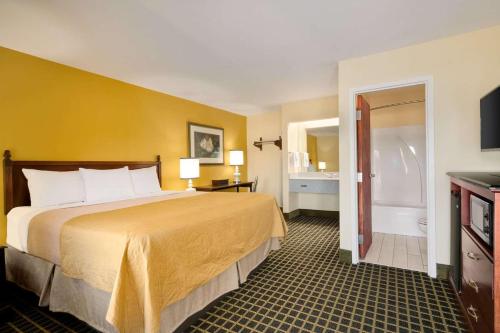 a hotel room with a large bed and a bathroom at Travelodge by Wyndham Unadilla - Perry Near I-75 in Unadilla