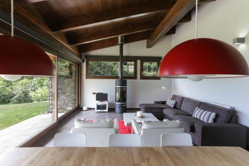 a living room with a black couch and white chairs at Cal Sadurní in Bruguera