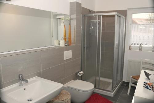 uma casa de banho com um WC, um lavatório e um chuveiro em Nordseestrand em Horumersiel