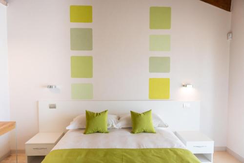 a bedroom with a bed with green pillows at I Boschetti in Magliano Alpi