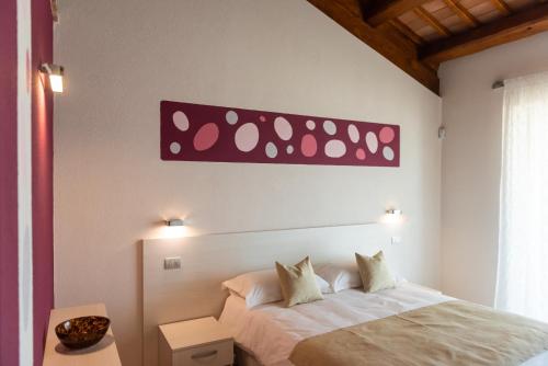 a bedroom with a bed with a pink sign on the wall at I Boschetti in Magliano Alpi