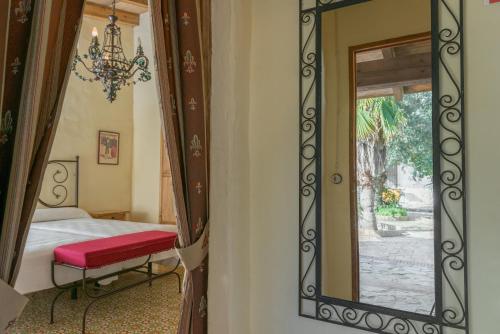 ein Schlafzimmer mit einem Spiegel, einem Bett und einem Fenster in der Unterkunft Cortijo Los Monteros in Benalup Casas Viejas
