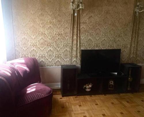 a living room with a couch and a flat screen tv at Classic Apartment on Kievyan in Yerevan