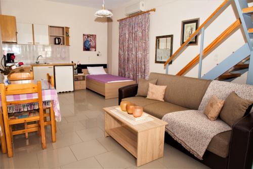 uma sala de estar com um sofá e uma mesa em Palmira Apartments em Makry Gialos