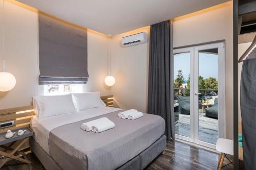 a bedroom with a bed with two towels on it at Sun Ray Luxury Apartments in Agia Marina Nea Kydonias