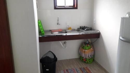 uma pequena cozinha com um lavatório e um balcão em Chales Flores de Sana em Sana