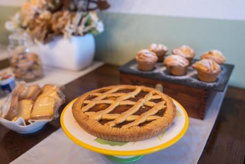 a pie on a yellow plate on a table with cupcakes at I Boschetti in Magliano Alpi