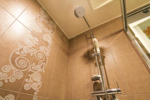 a shower stall in a bathroom with a shower curtain at Q Hotel Yongin in Yongin