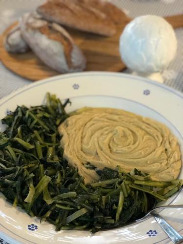 a plate of food with pasta and green vegetables at Itaca Home to Explorers in Polignano a mare in Polignano a Mare