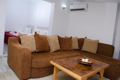 a living room with a brown couch and a coffee table at Villa Re3ca in Skopje