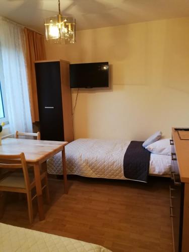 a hotel room with a bed and a table at Noclegi u Mai in Olsztyn