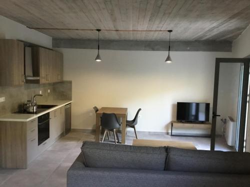 a living room with a couch and a table and a kitchen at Lagkada Suites in Kariá