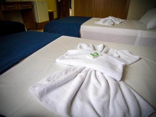 a pair of towels sitting on top of a bed at Estrela do Sul Hotel in Curitiba