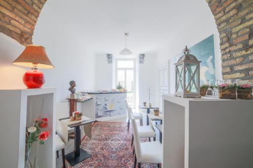 ein Wohnzimmer mit weißen Wänden sowie einem Tisch und Stühlen in der Unterkunft Roman Holidays cuore dell'Impero in Rom