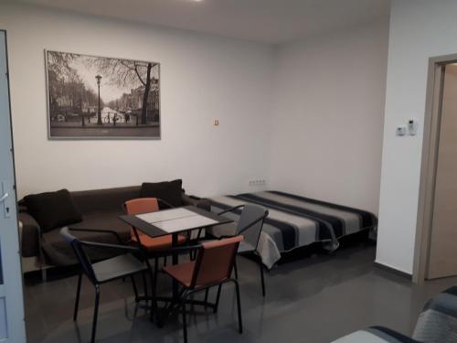 ティサウーイバーロシュにあるKertvárosi Apartman IIのソファ、テーブル、椅子が備わる客室です。