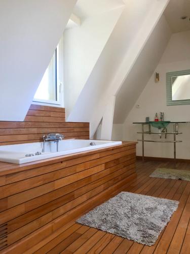 - une grande salle de bains mansardée pourvue d'une baignoire dans l'établissement Superbe Villa Individuelle avec Piscine et Tennis privatifs, à Villers-sur-Mer