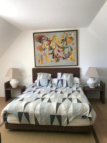 une chambre avec un lit avec un tableau sur le mur dans l'établissement Superbe Villa Individuelle avec Piscine et Tennis privatifs, à Villers-sur-Mer