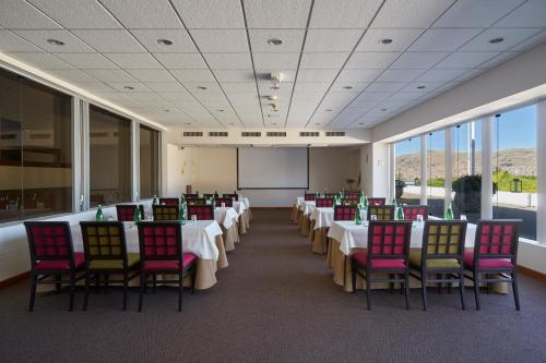 a conference room with tables and chairs and a whiteboard at GHL Hotel Lago Titicaca in Puno