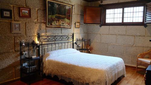 una camera con letto e muro di mattoni di Casa en finca de uva con piscina privada, cubierta y climatizada a La Degollada