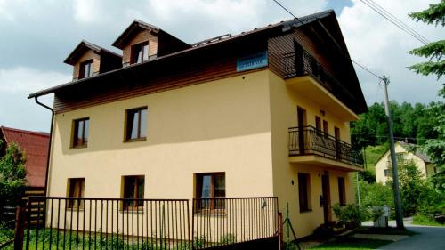a large yellow house with a black roof at Rekreačný dom pod Dedovou in Oščadnica