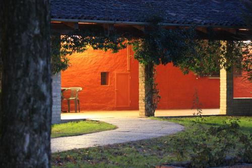 a pathway leading to a red building with a red door at Agriturismo La Lupa in Madonna della Provvidenza