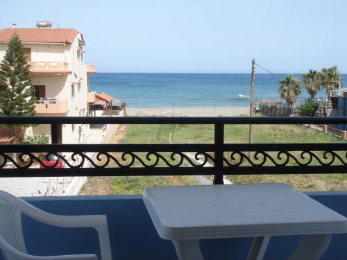 a balcony with a table and a view of the beach at Emi Seaside in Amoudara Herakliou