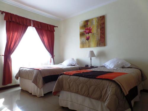 a hotel room with two beds and a window at Gran Hotel Ovalle in Ovalle