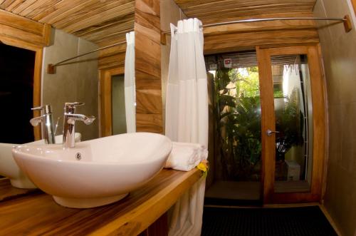 a bathroom with a white sink and a window at Beqa Lagoon Resort in Beqa Island