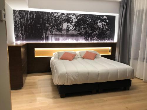 a bedroom with a bed with white sheets and red pillows at Auberge de la Tour in Trélex