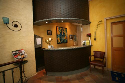 a bar in a restaurant with a counter and a chair at Hôtel La Tour Intendance in Bordeaux