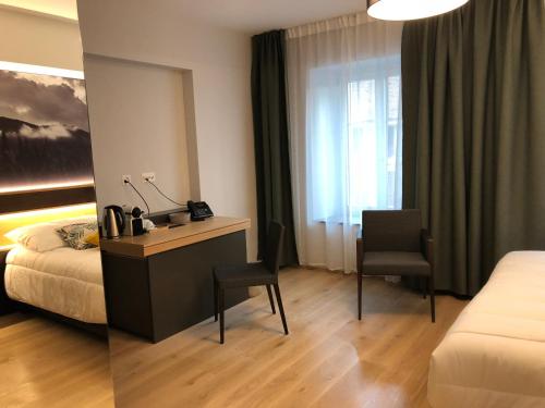 a hotel room with a bed and a desk and chair at Auberge de la Tour in Trélex