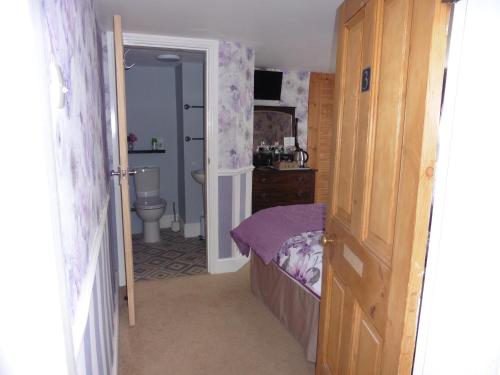 a small bedroom with a bed and a bathroom at Hillside Bed and Breakfast in Bedale
