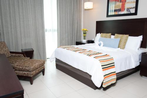 a hotel room with a large bed and a chair at Summit Rainforest Golf Resort & All Inclusive in Paraíso