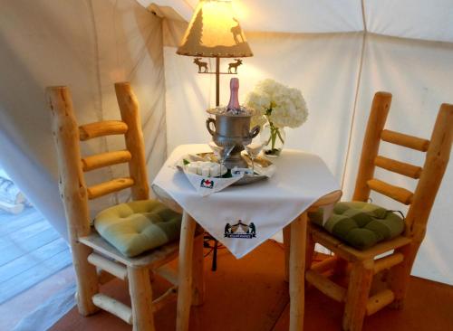 un tavolo con due sedie, una lampada e dei fiori sopra di WildExodus Outdoors a Timmins