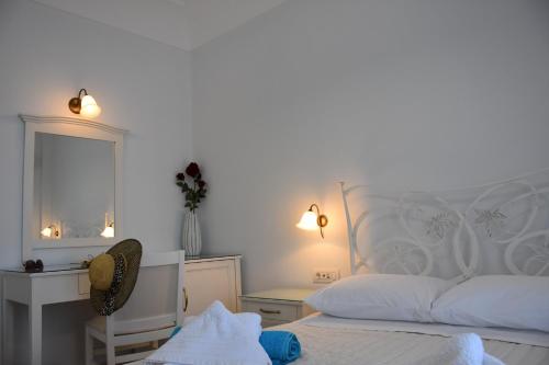 a bedroom with a white bed and a mirror at Arion Bay Hotel Santorini in Kamari