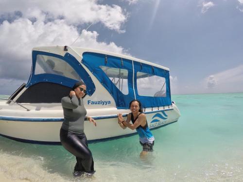 a man and a woman on a boat in the ocean at Salt Beach Hotel in Maafushi