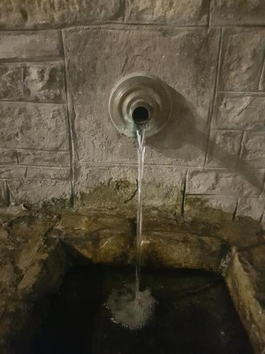 a water fountain with water coming out of it at Εn Kanalion in Kanália