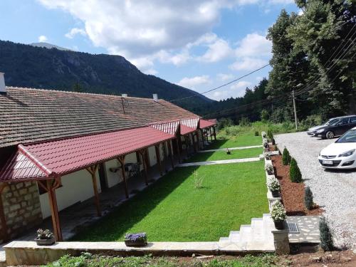 a building with a green lawn in front of it at Apartmani Gmitrovic in Rtanj