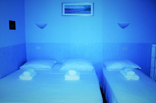 two twin beds in a room with blue lights at Hotel Moon Light in Rome
