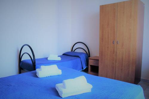 a room with two beds with blue sheets and a cabinet at Hotel Moon Light in Rome