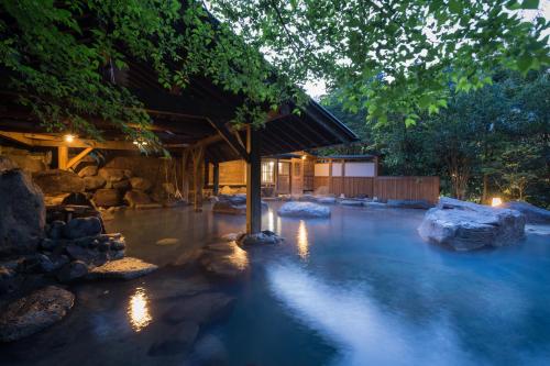 a pool of water with rocks in front of a building at Yamabiko Ryokan in Minamioguni