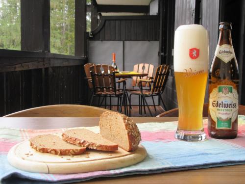 a table with a plate of bread and a bottle of beer at Hochkönig Top 6 in Mühlbach am Hochkönig