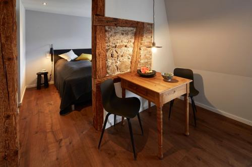 uma sala com uma mesa e uma cama e um quarto em Guesthouse Bärenbad em Staufen im Breisgau
