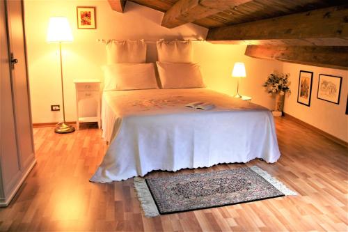 una camera con un grande letto con due lampade e un tappeto di Appartamento Il Cappero a Modica