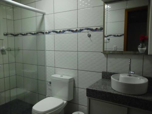 a bathroom with a toilet and a sink and a mirror at Pousada Apartamento na Serra in Nova Petrópolis