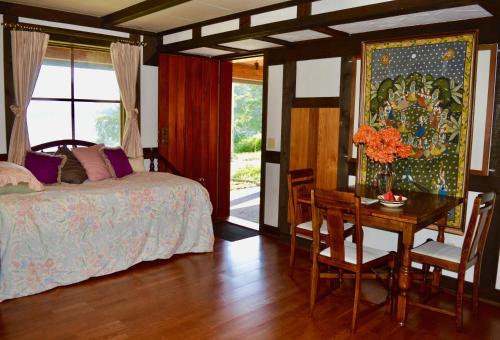een slaapkamer met een bed, een bureau en een tafel met stoelen bij Oceanfront Suite in Gibsons