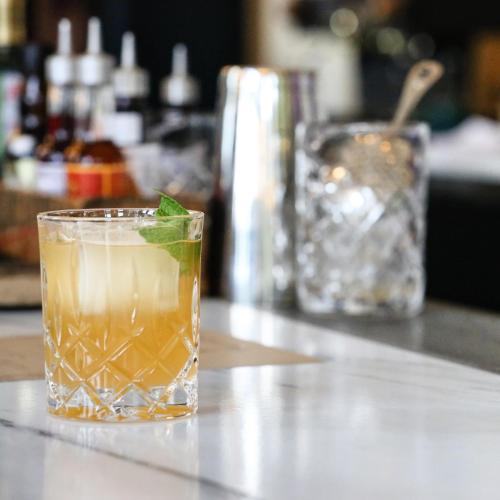 a drink with a green leaf in a glass on a counter at Surf Hotel & Chateau in Buena Vista
